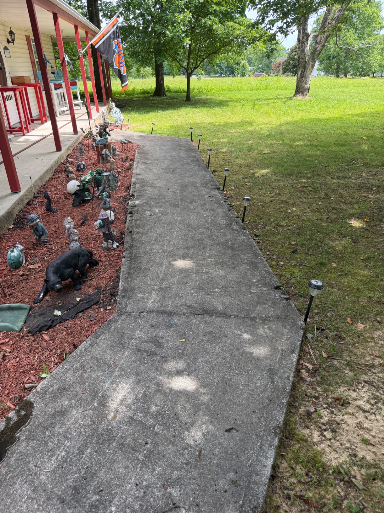 Porch walkway before cleaning with darker concrete around the entry